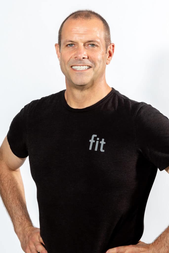 A man in a black t - shirt is posing for a photo.