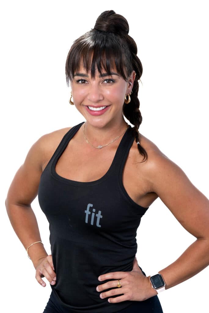 A woman in a black tank top posing for a photo.