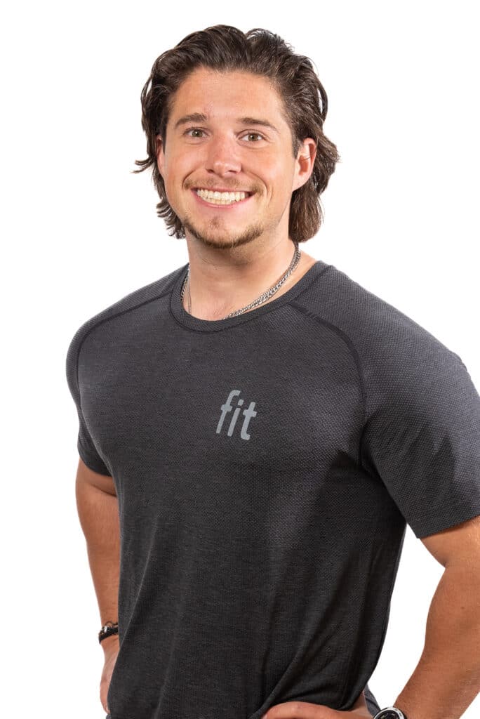 A man wearing a grey t - shirt with his hands on his hips.