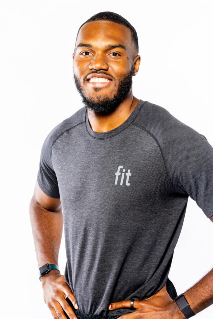 A black man wearing a grey t - shirt posing for a photo.