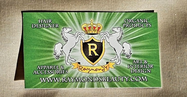 Business card with a green background featuring a crest with two white horses and a crown. Text includes "Raymond's Beauty" and services like hair design, organic products, and apparel.